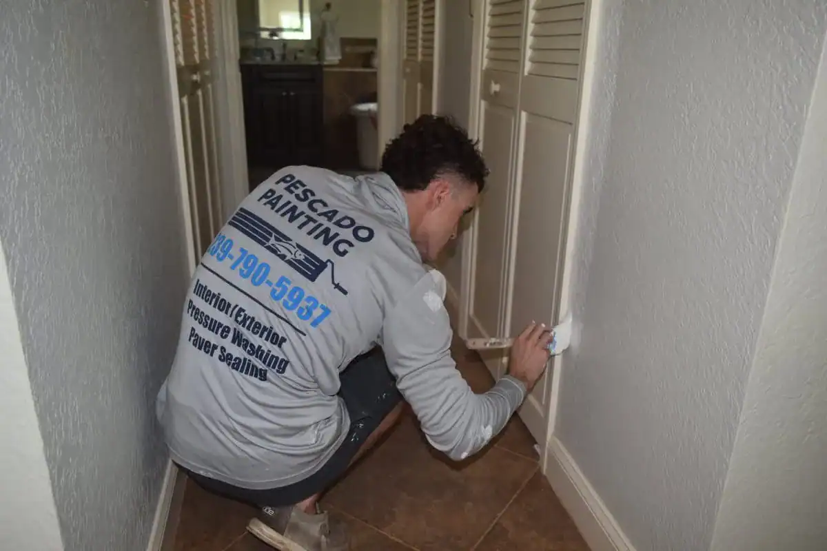 Expert Trim Painting and Detail Work in Southwest Florida A painter meticulously applying paint to trim in a hallway in a Southwest Florida home.