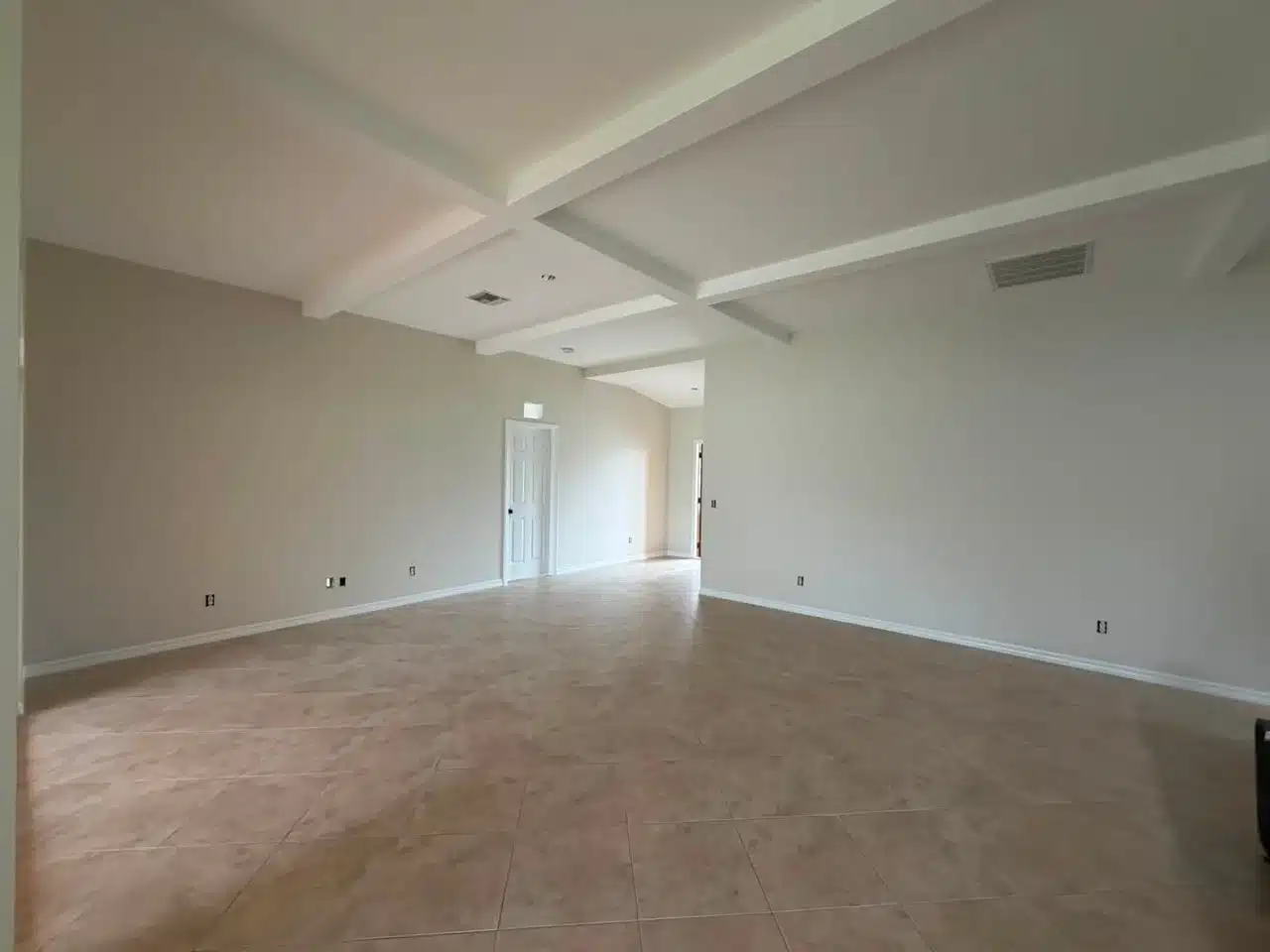 Beige Walls White Coffered Ceiling Beige painted walls with white coffered ceiling and light wood-look tile flooring in open residential interior