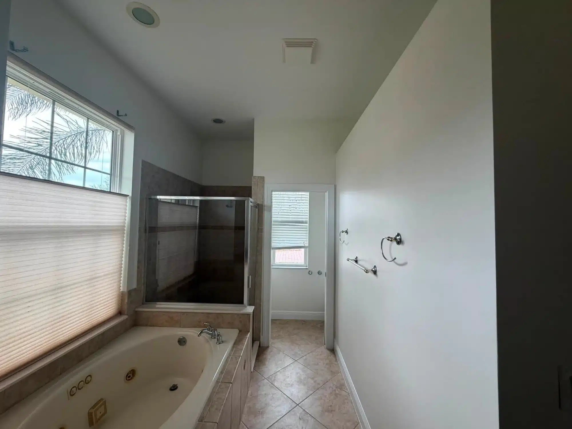 Interior Residential Bathroom Painting White painted bathroom walls and ceiling with dark tile flooring, jetted tub, and glass shower enclosure in Cape Coral, FL